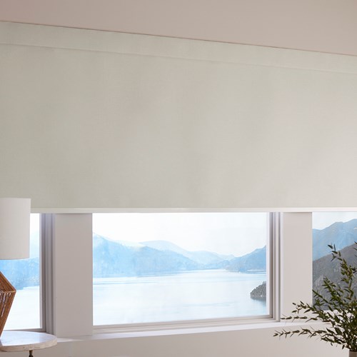 The Motorized Blackout Roller Shades in the Catania Off-White color with the Fabric Wrapped 4in. Cornice.