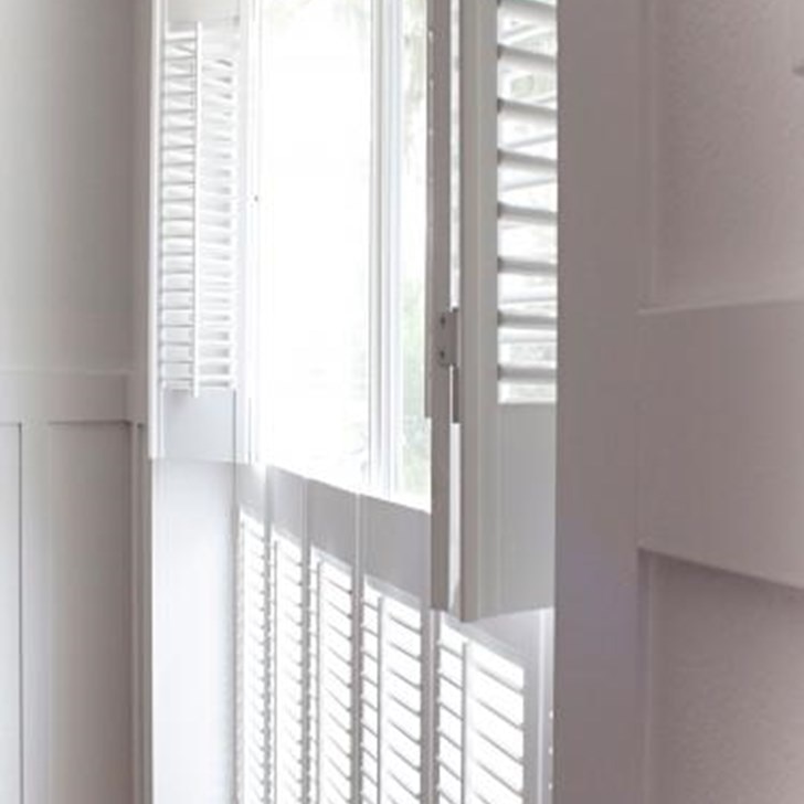 Customer Tiffany from Making the World Cuter gave her living room a charming vintage feel with double hung Simplicity Cottage Wood Shutters.