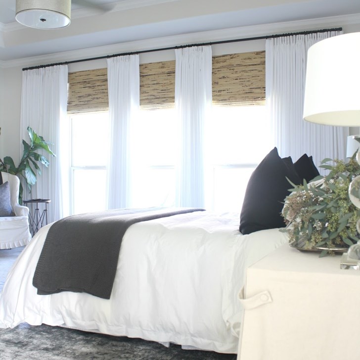 Customer Shelley gave her bedroom privacy and texture with Woven Wood in Antigua Natural and the Easy Classic Pleat Drapes in Lexi White. Photo via Crazy Wonderful.
