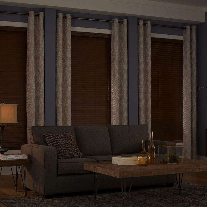 Layer your window treatment with drapery panels. Shown here in Bombay Sand with the Premier 2in Faux Wood Blinds