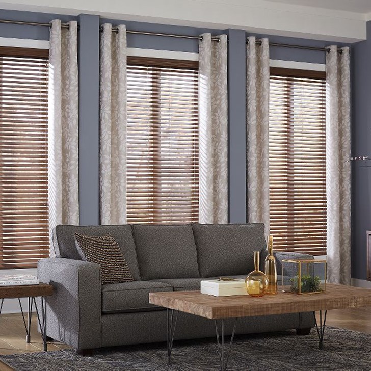 Layer your window treatment with drapery panels. Shown here in Bombay Sand with the Premier 2in Faux Wood Blinds